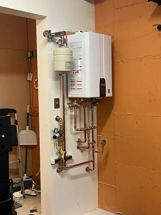 Plumbing technician inspecting water heater connections in Ava
